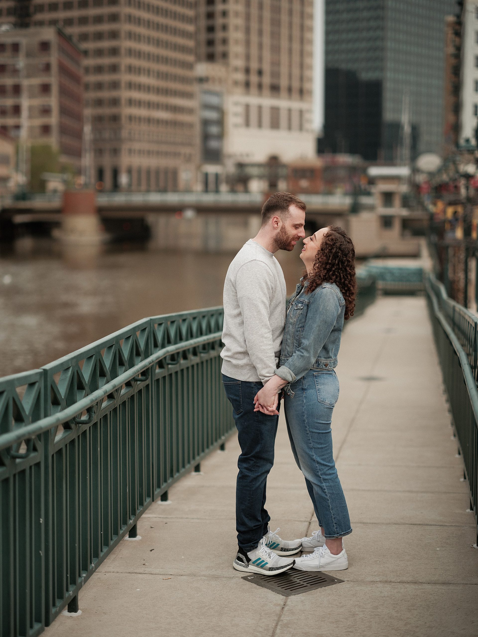 couple kisses in downtown milwaukee near river